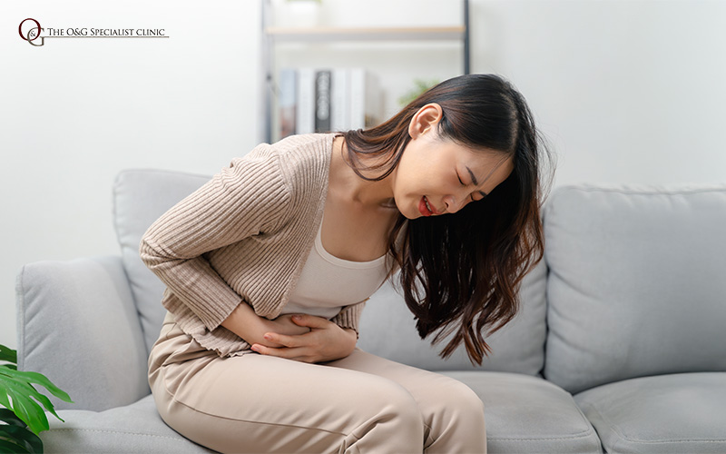 A woman holding her stomach in period pain.