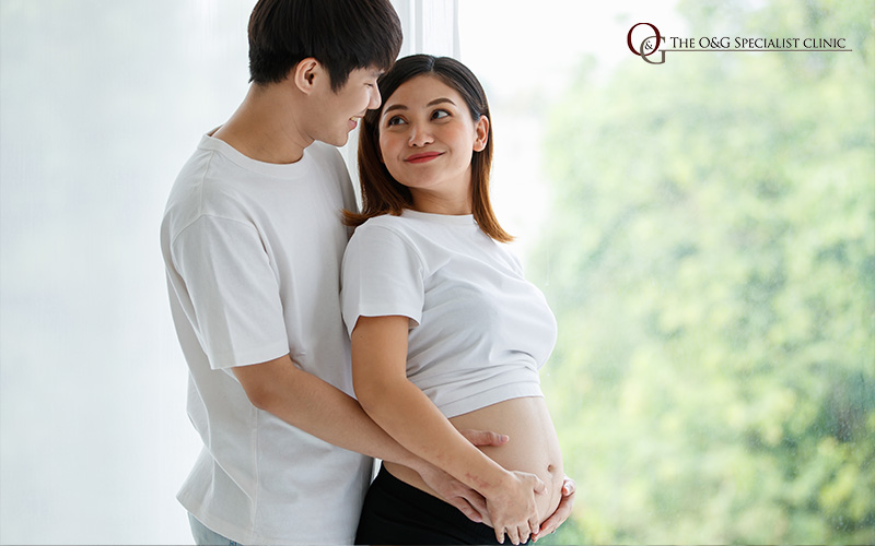 Couple happily embracing, celebrating pregnancy.