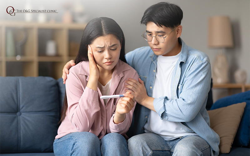 Couple looking at a negative pregnancy test.